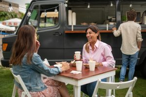 Cheerful women discussing project in street cafe